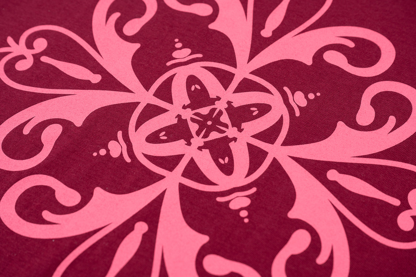 Detalle de diseño de azulejo rosa sobre espalda en camiseta de manga corta unisex color burdeos