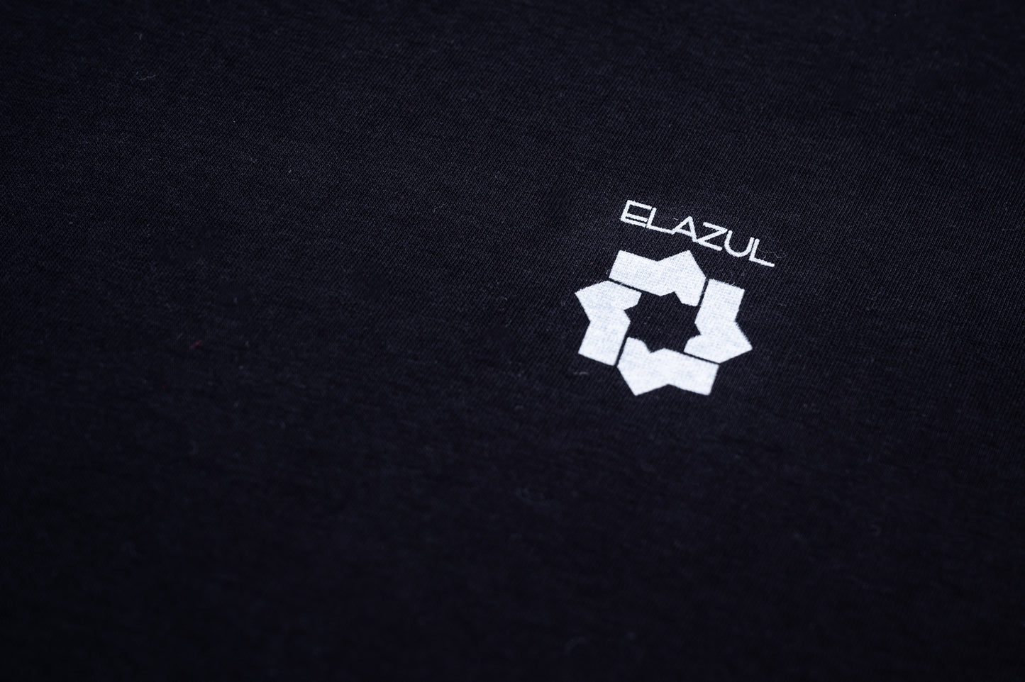 Detalle de logo blanco en pecho sobre camiseta de manga corta unisex color negro