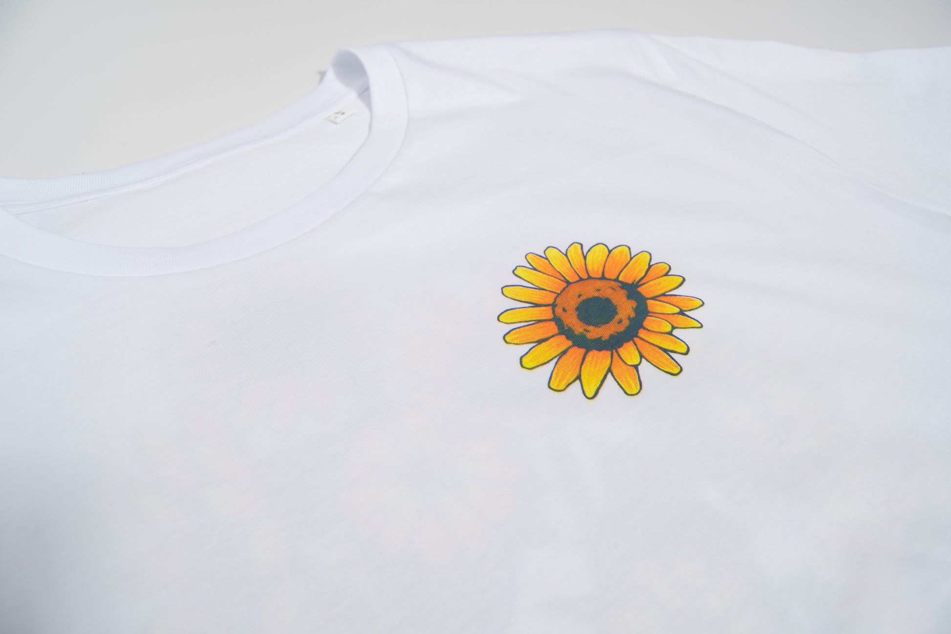 Disfruta de esta camiseta de edición limitada. Tejido de algodón orgánico y estampación con serigrafía manual mediante técnica de cuatricromía. Su diseño colorido de girasoles seguro que te alegra un poquito el día.  Tejido de 150gr/m2, cómodas y suaves para uso habitual.  100% Algodón Orgánico